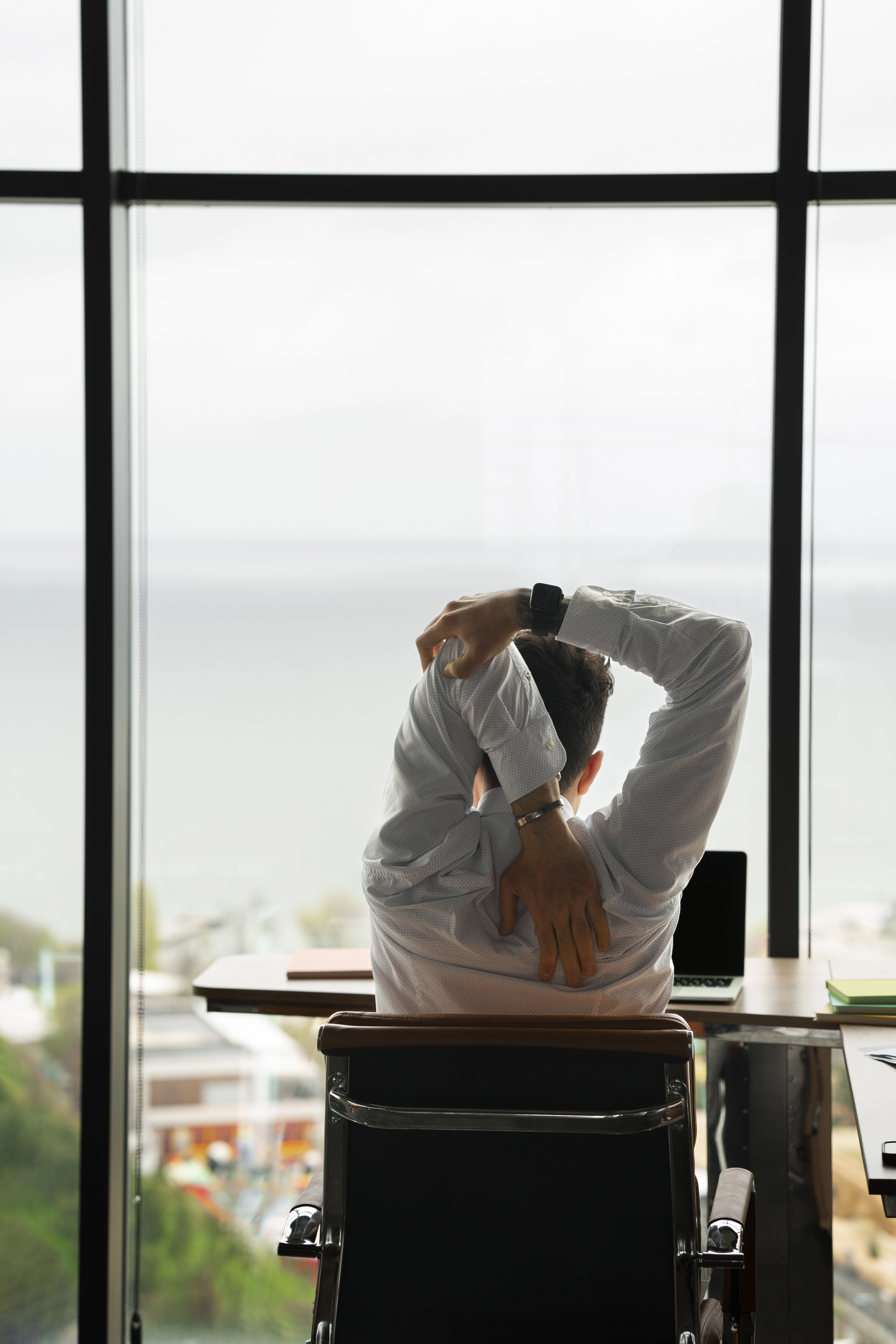 vue-arriere-homme-qui-s-etend-au-travail